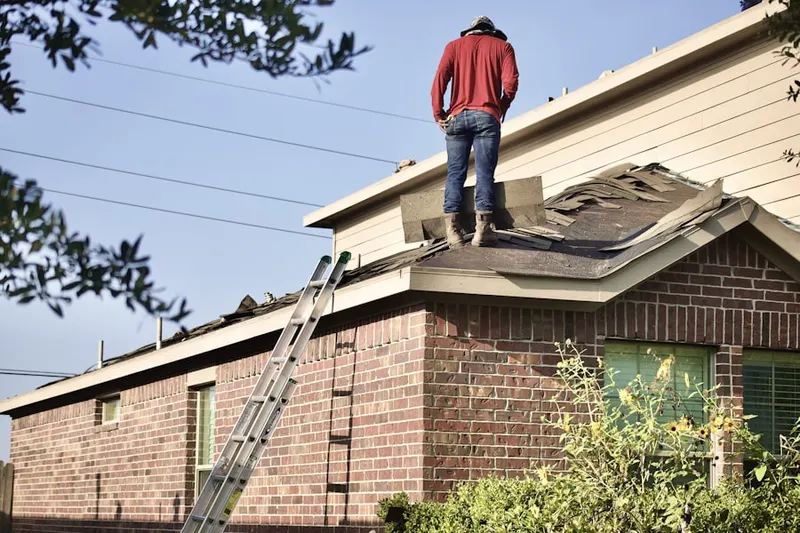 Professional roofer working on a residential roof in Naples Manor